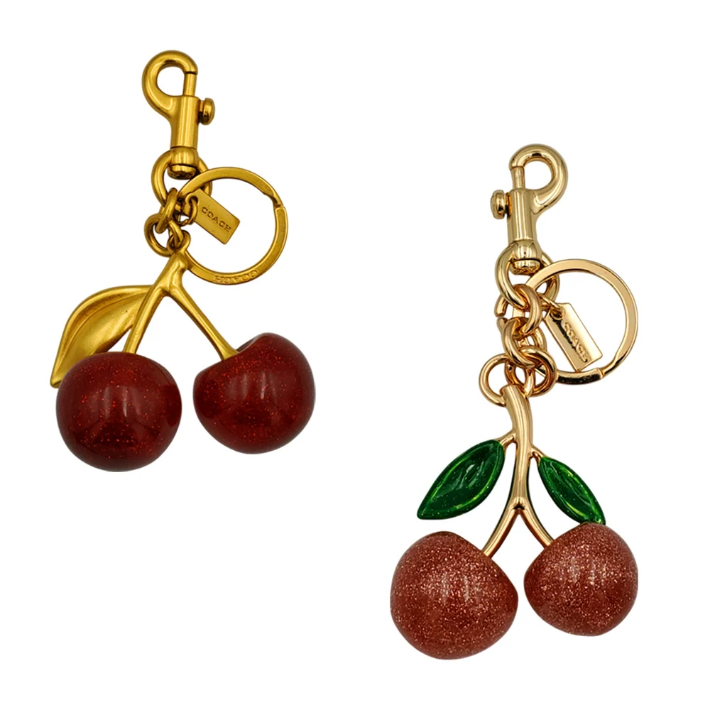 Llavero dorado con forma de cerezas, variedad de colores y diseños